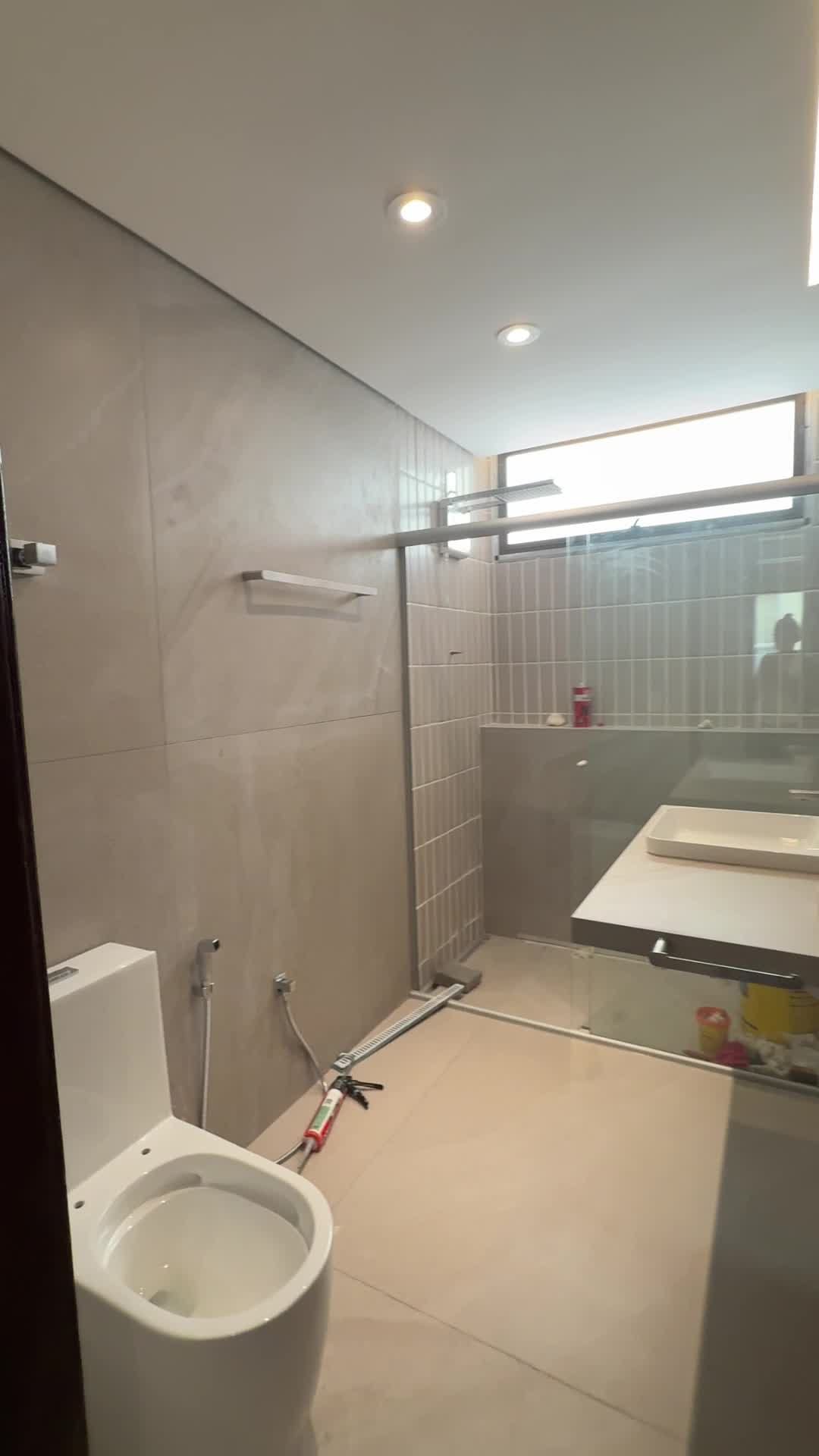 Banheiro do apartamento com porcelanato de grande formato, faixa em pastilha vertical no box e ralo linear