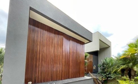 Detalhe do brise de madeira e do beiral em concreto na fachada da residência