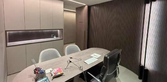 Sala de atendimento do consultório com marcenaria planejada e nicho iluminado