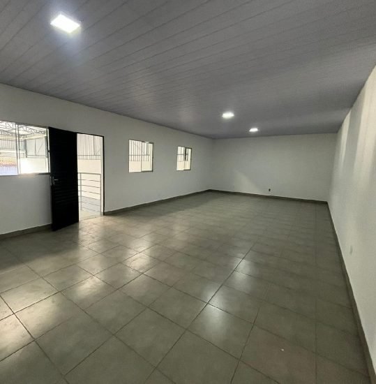 Área de escritório interna do galpão, com piso cerâmico e iluminação em luminárias embutidas